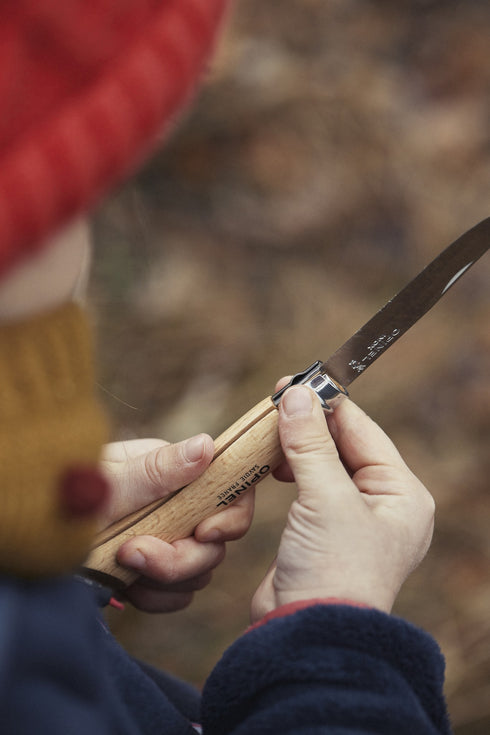 Enfant taillant une branche avec son couteau Mon premier Opinel