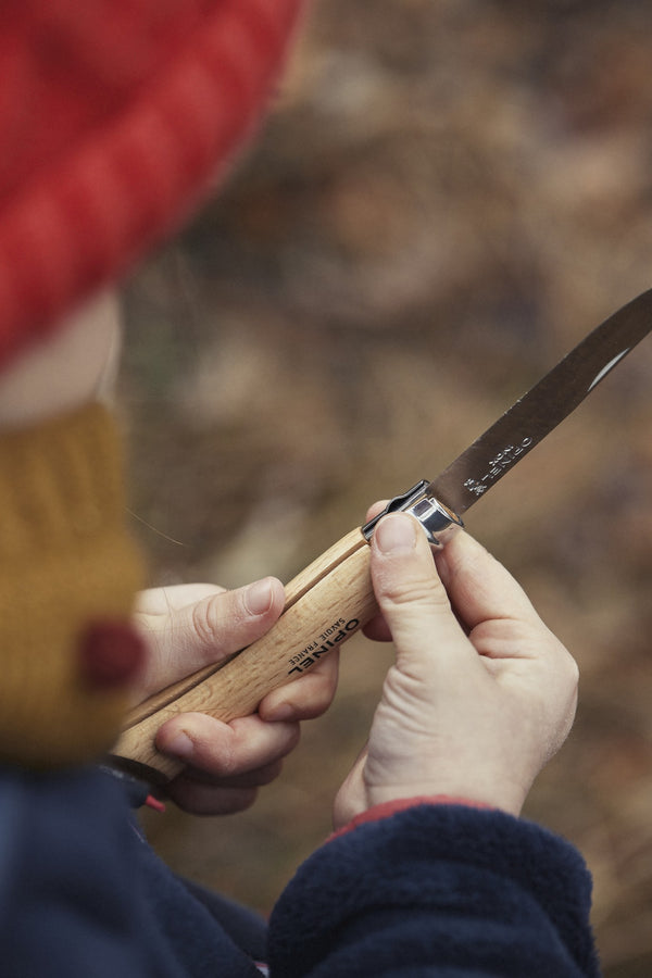 Enfant taillant une branche avec son couteau Mon premier Opinel