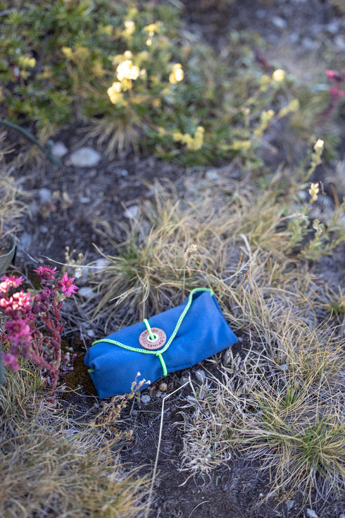 Étui des couverts Picnic+ posé dans l'herbe en montagne