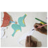 Enfant coloriant un dinosaure en papier au feutre