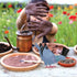 Enfant façonnant des bombes de graines dans un champ de fleurs