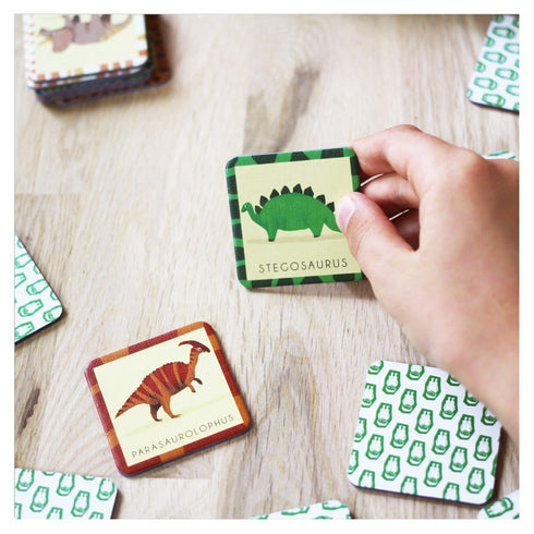 Main tenant une carte de stégosaure du jeu de mémoire