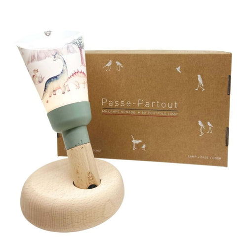 Lampe Passe-Partout Dinosauria vert sauge sur son socle en hêtre, devant son coffret