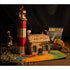 Maquette du phare peinte en rouge et blanc, dans un décor marin