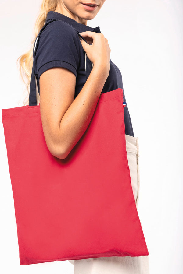 Sac shopping coton rouge porté à l'épaule, fabriqué en France