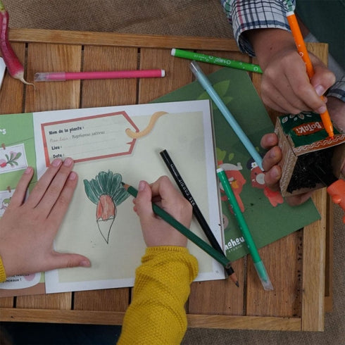 Enfant remplissant le carnet d'exploration Botaki